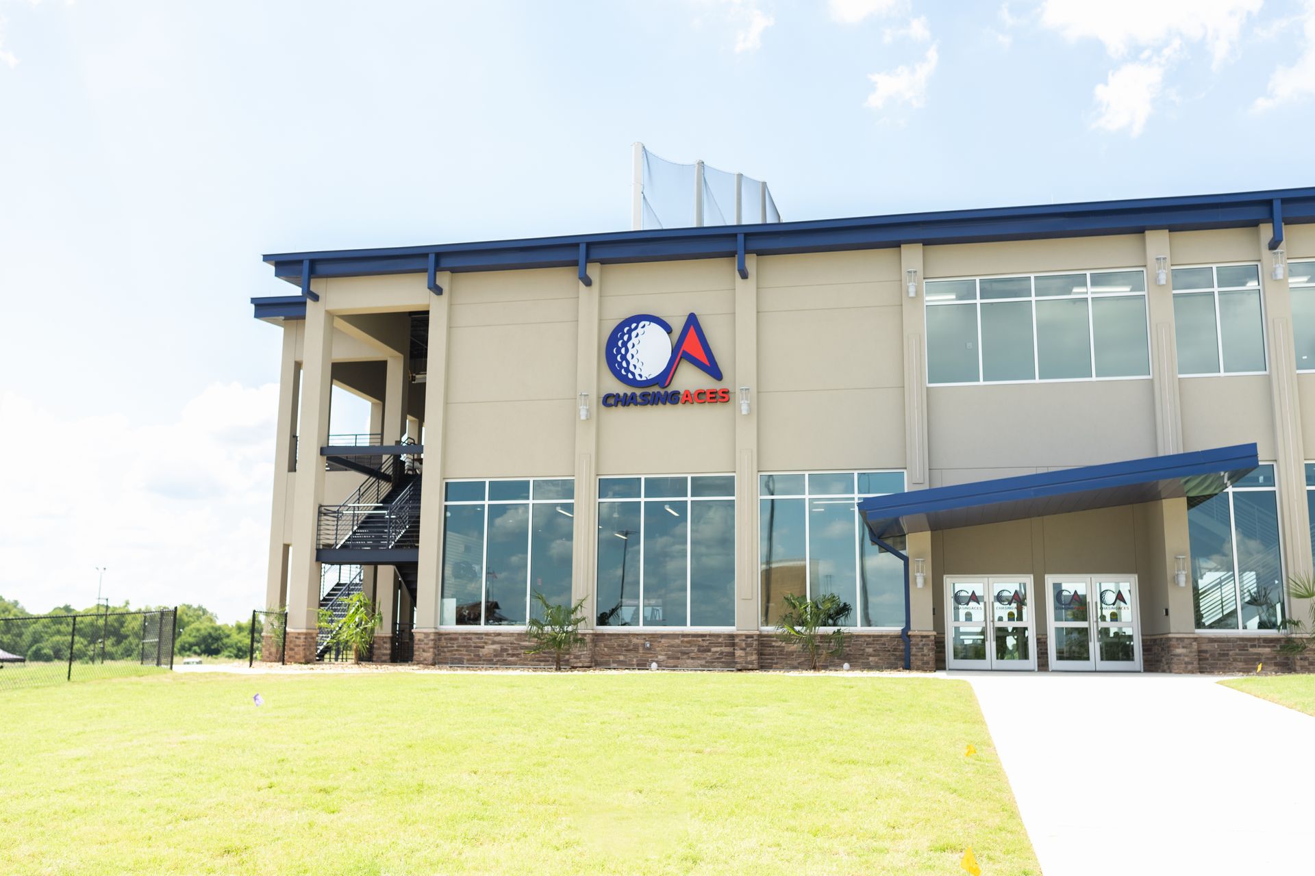Modern two-story building with blue trim and a large grassy lawn in front