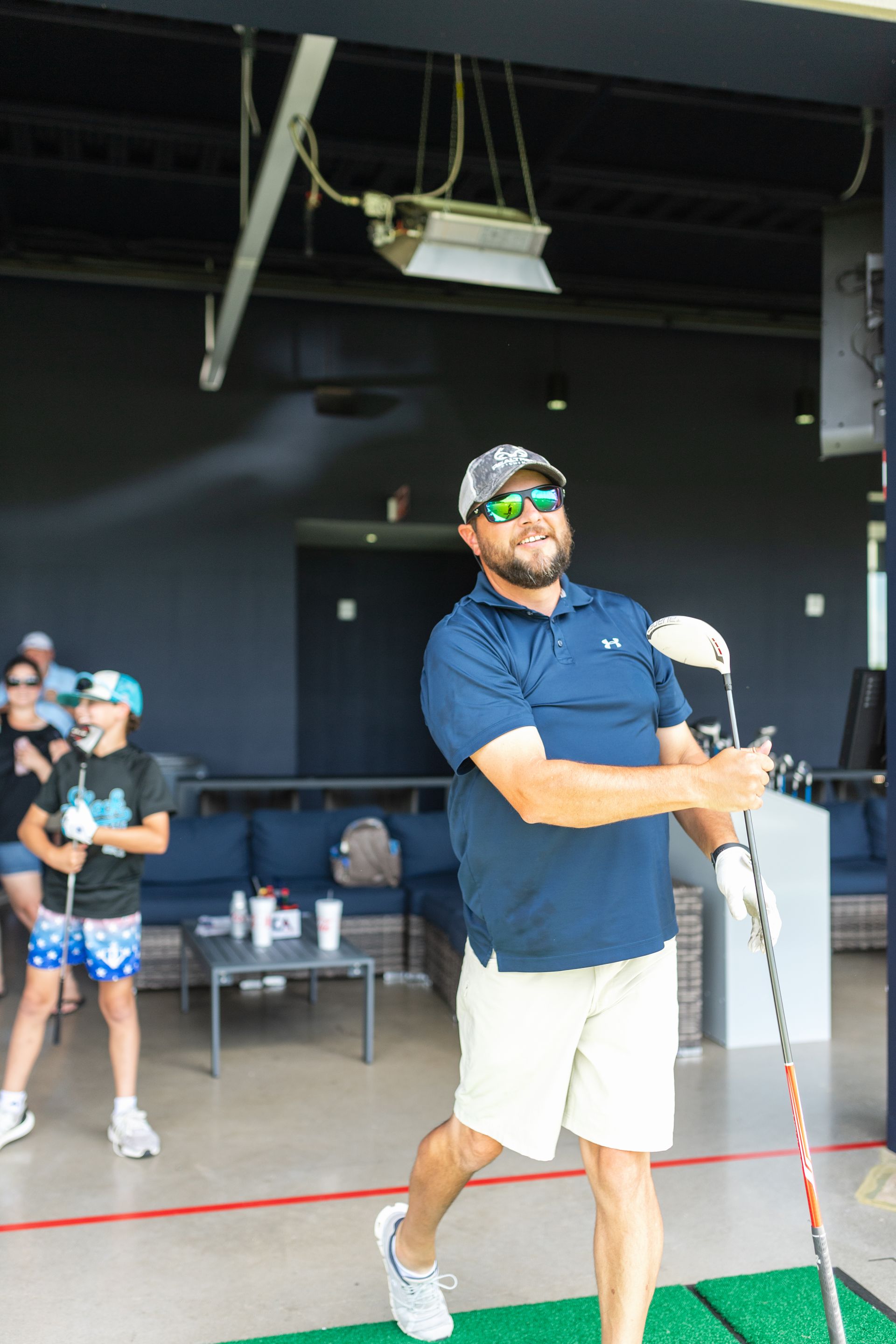 A man is swinging a golf club on a driving range