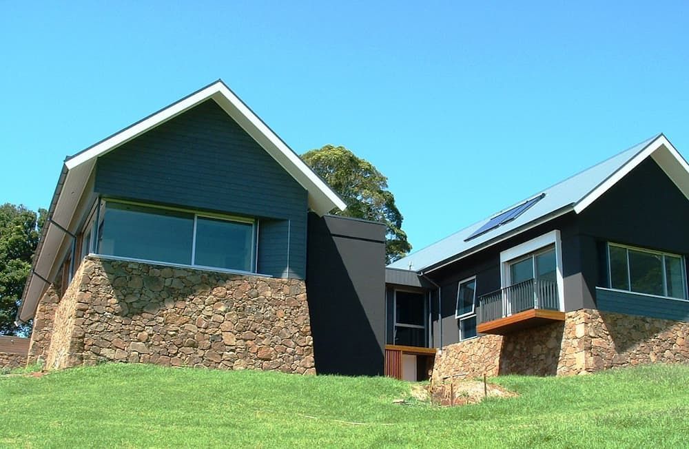 A Couple Of Houses Sitting On Top Of A Grassy Hill — South Coast Glass In South Nowra, NSW
