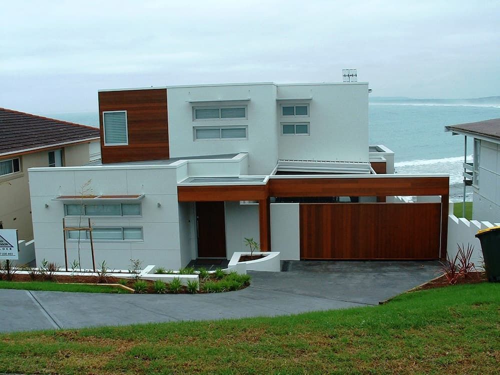 A White House With A Wooden Garage Door And A View Of The Ocean — South Coast Glass In South Nowra, NSW
