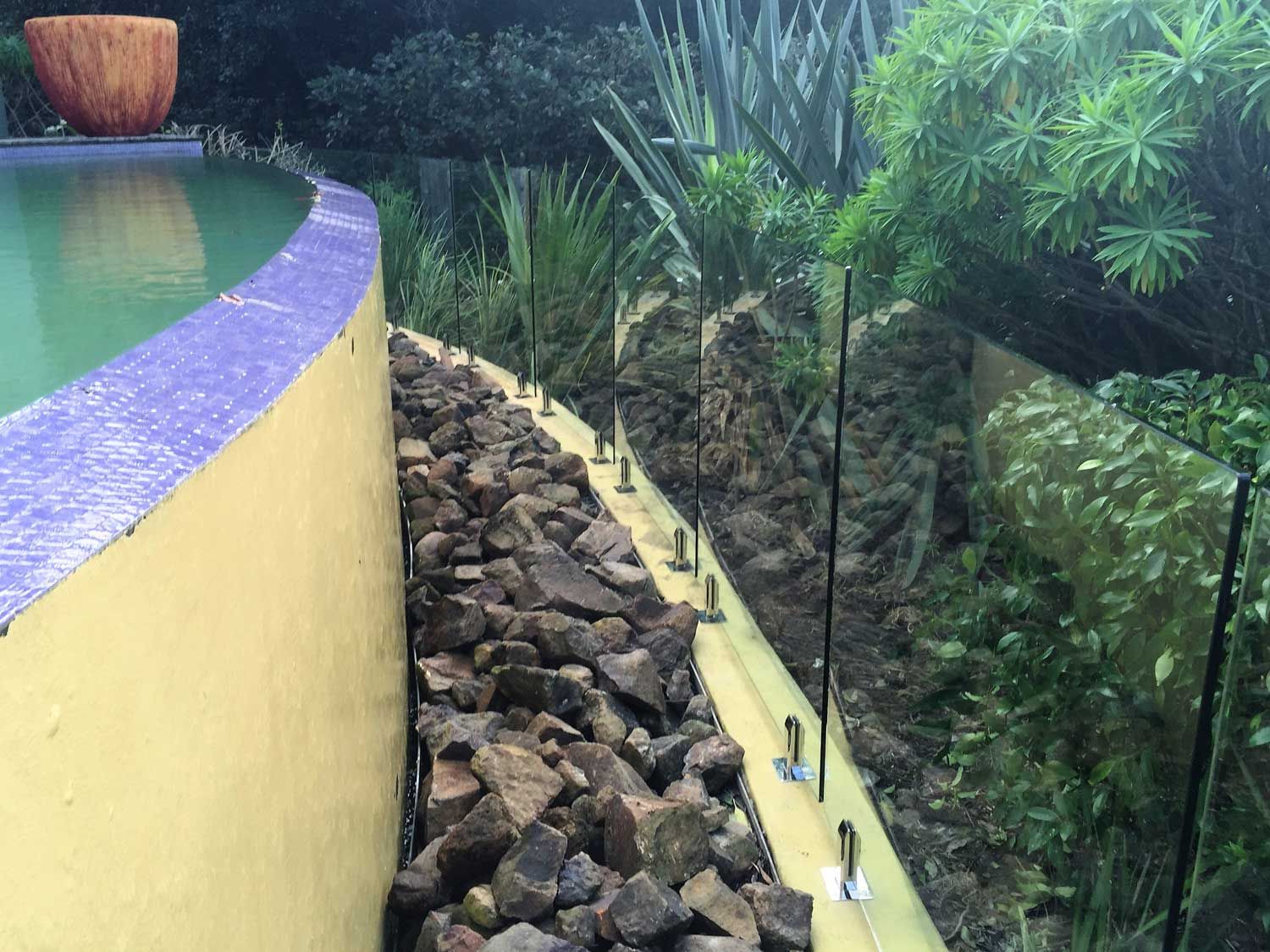 A Pool Yellow Paint Wall and Glass Fencing — South Coast Glass In South Nowra, NSW