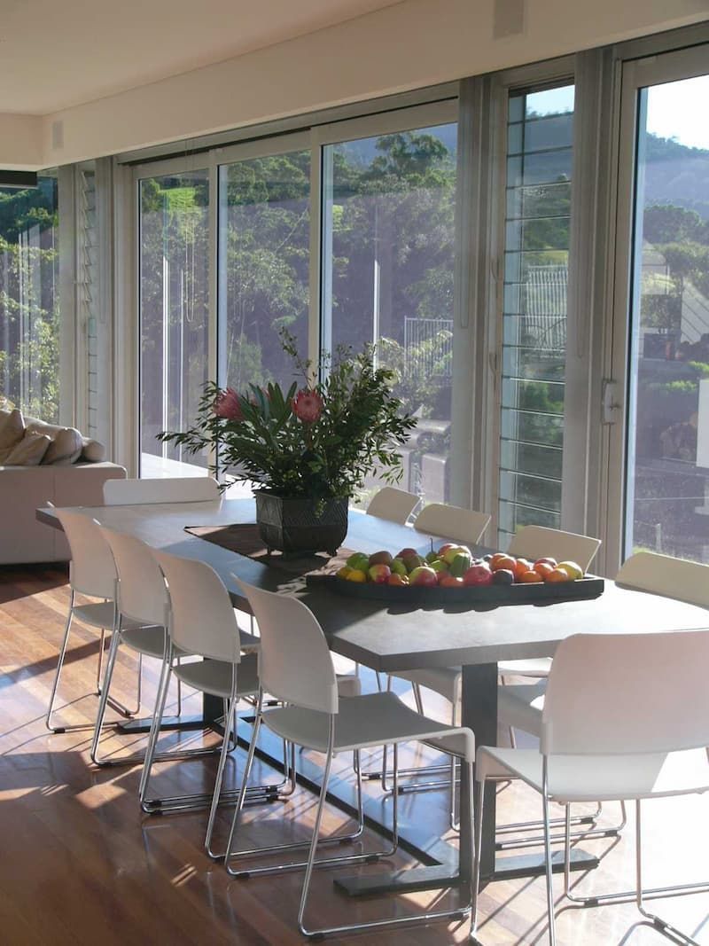 A Dining Room Table With A Vase Of Flowers On It — South Coast Glass In South Nowra, NSW