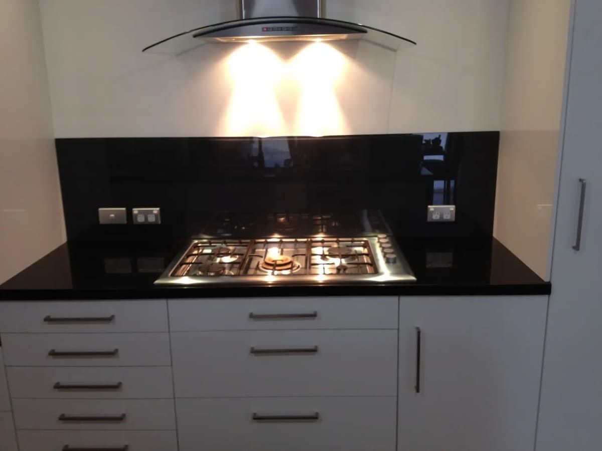 A Kitchen With White Cabinets And A Stove Top Oven — South Coast Glass In South Nowra, NSW