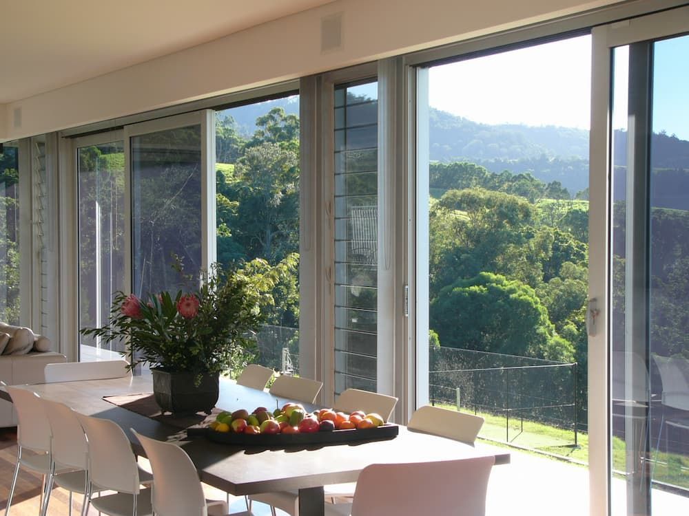 A Dining Room Table With A Vase Of Flowers On It — South Coast Glass In South Nowra, NSW