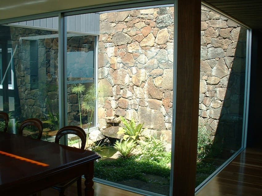 A Room With A Table And Chairs In Front Of A Stone Wall — South Coast Glass In South Nowra, NSW
