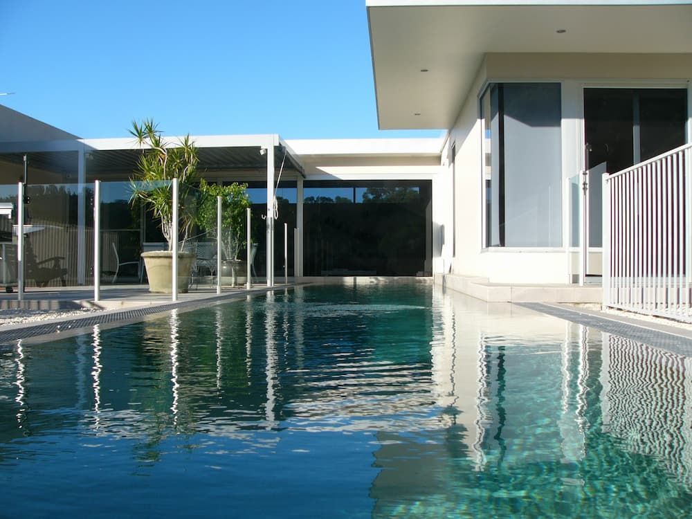 A House With A Large Swimming Pool In Front Of It — South Coast Glass In South Nowra, NSW