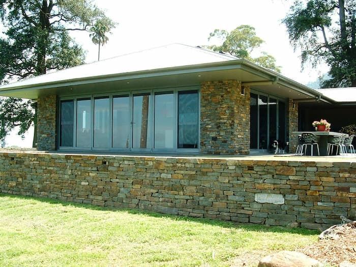 A House With A Stone Wall Surrounding It — South Coast Glass In South Nowra, NSW