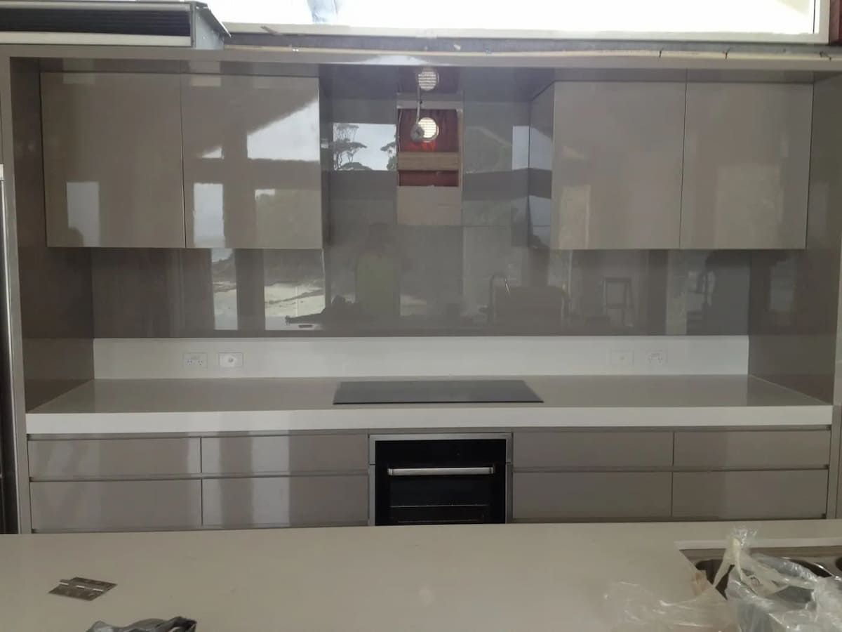 A Kitchen With White Cabinets And A Stove Top Oven — South Coast Glass In South Nowra, NSW