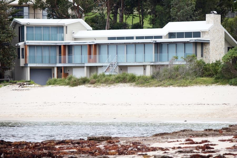 A Large House Sits On The Shore Of A Beach — South Coast Glass In South Nowra, NSW