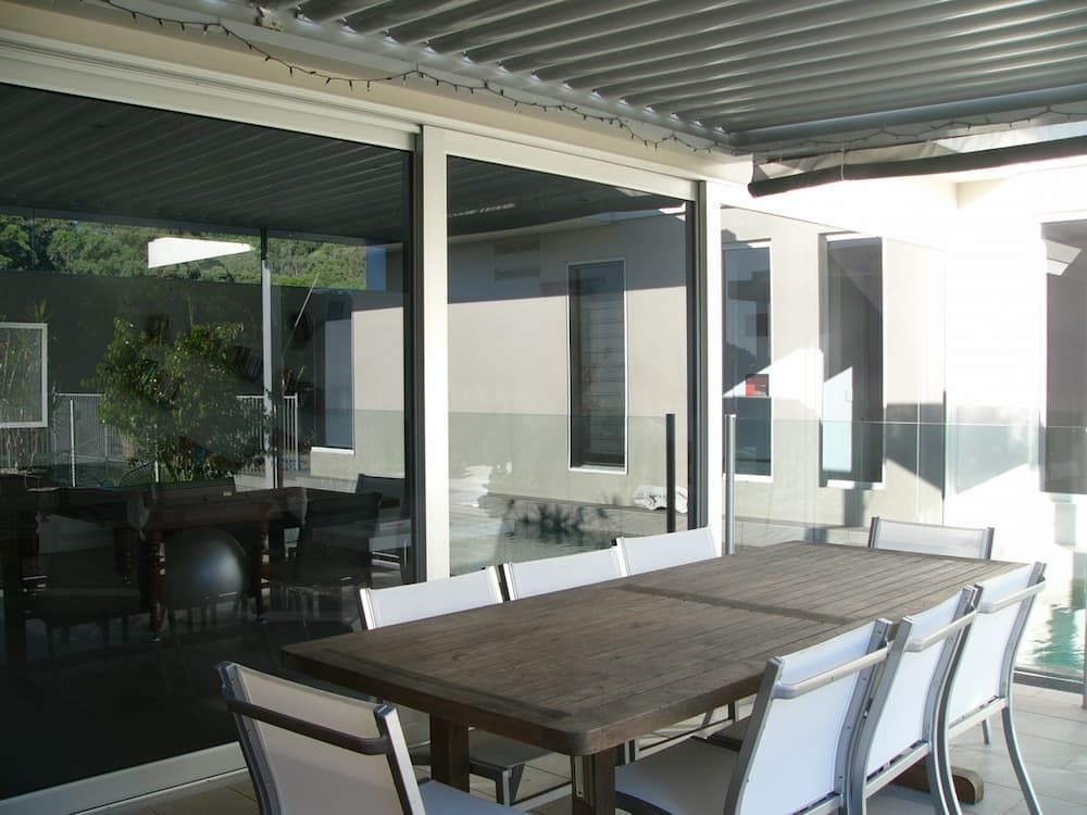 A Patio With A Table And Chairs Under A Roof — South Coast Glass In South Nowra, NSW