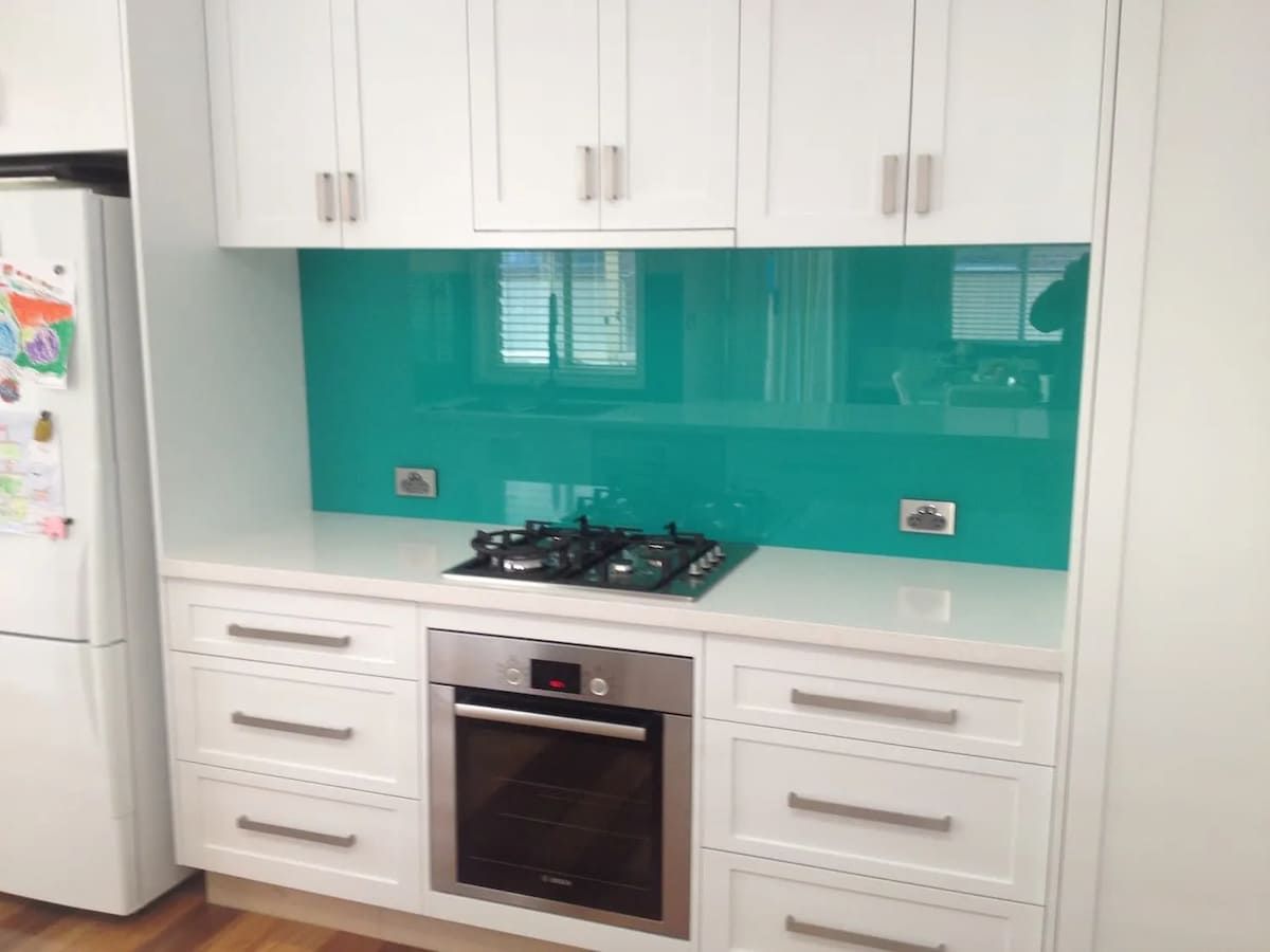 A Kitchen With White Cabinets And A Stove Top Oven — South Coast Glass In South Nowra, NSW