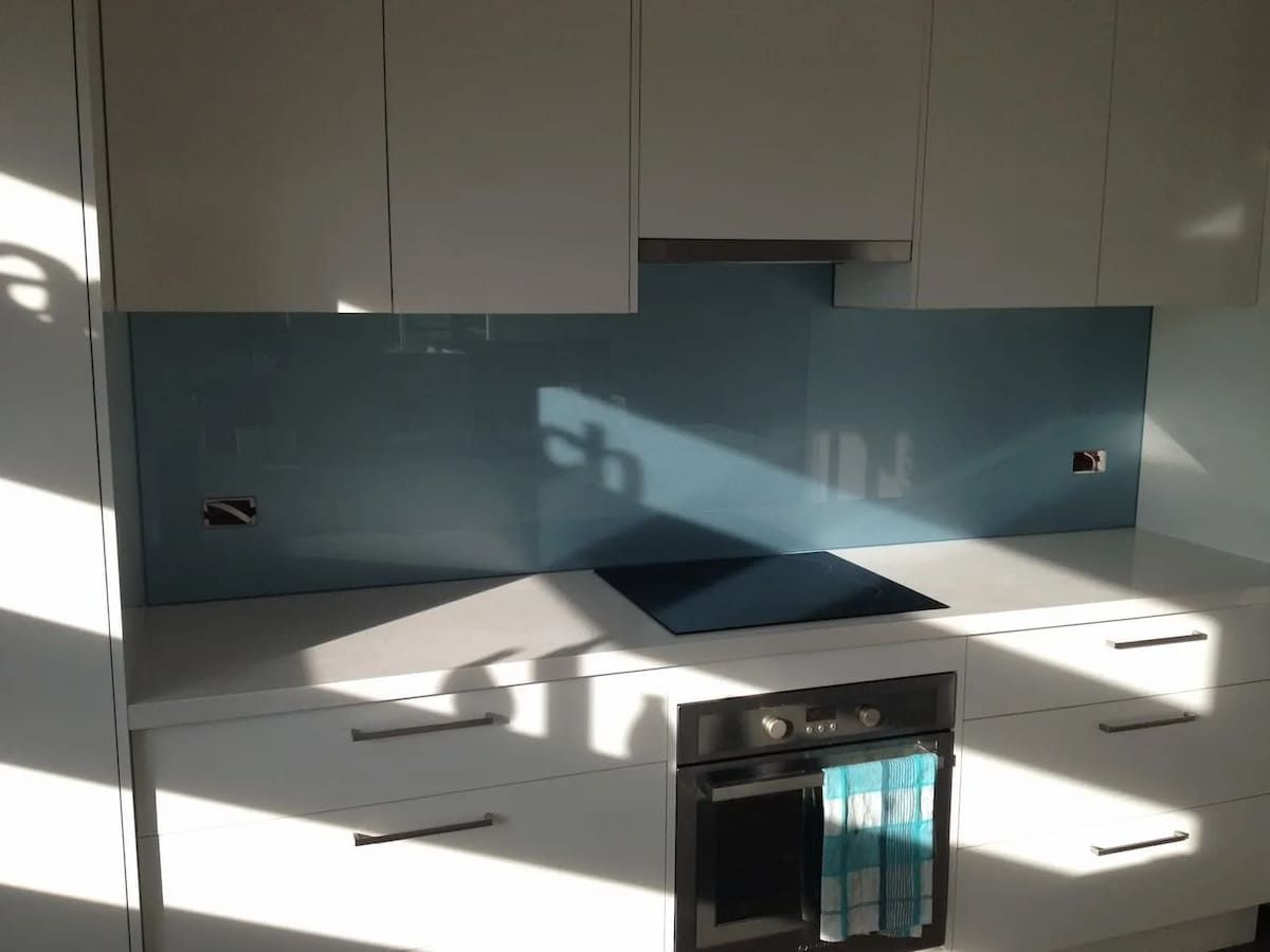 A Kitchen With White Cabinets And A Stove Top Oven — South Coast Glass In South Nowra, NSW