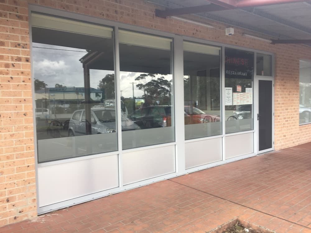 A Brick Building With A Lot Of Windows And A Door — South Coast Glass In South Nowra, NSW