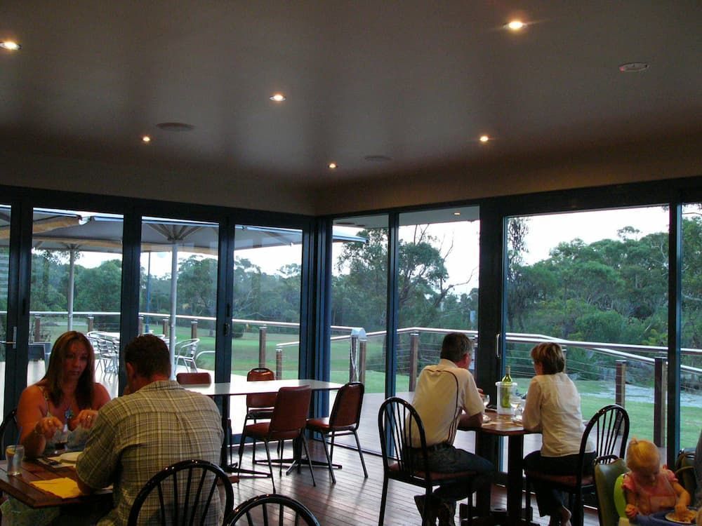 A Group Of People Are Sitting At Tables In A Restaurant — South Coast Glass In South Nowra, NSW