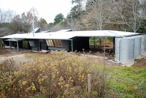 A Large House With A White Roof Is Surrounded By Trees And Grass — South Coast Glass In South Nowra, NSW