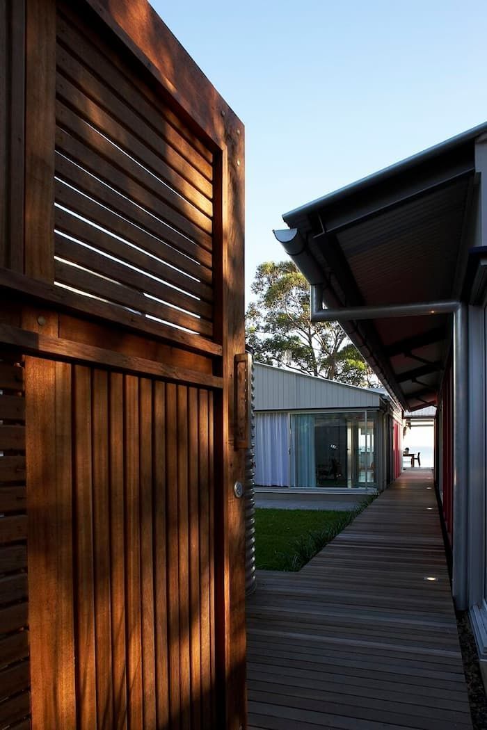 A Wooden Walkway Between Two Buildings With A Wooden Fence — South Coast Glass In South Nowra, NSW