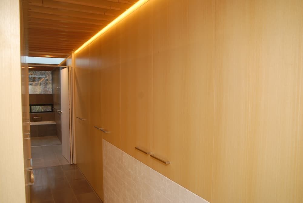 A Hallway With Wooden Cabinets And A Light On The Ceiling — South Coast Glass In South Nowra, NSW
