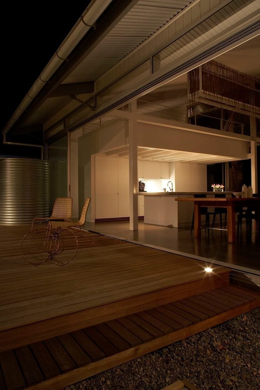A House With A Wooden Deck Is Lit Up At Night — South Coast Glass In South Nowra, NSW