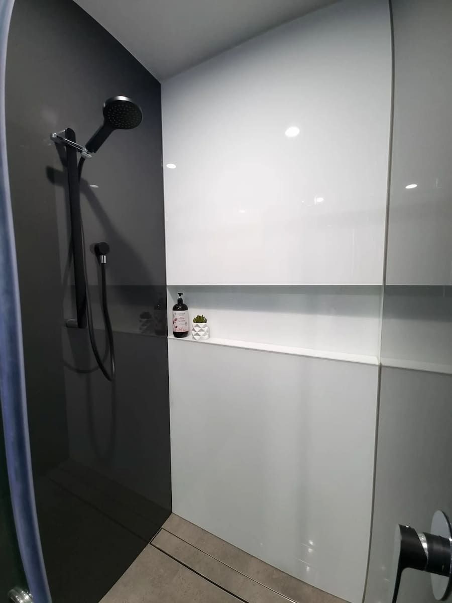 A Shower With A Black And White Wall And A Black Shower Head — South Coast Glass In South Nowra, NSW