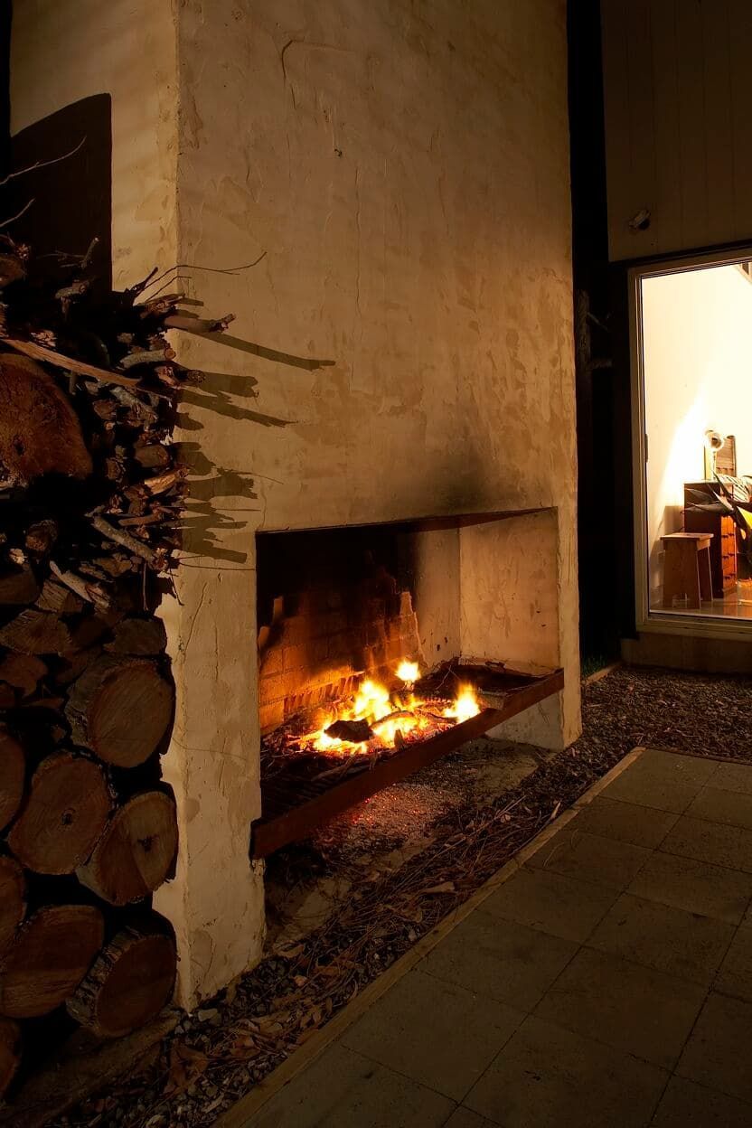 A Fireplace With A Pile Of Logs In Front Of It — South Coast Glass In South Nowra, NSW