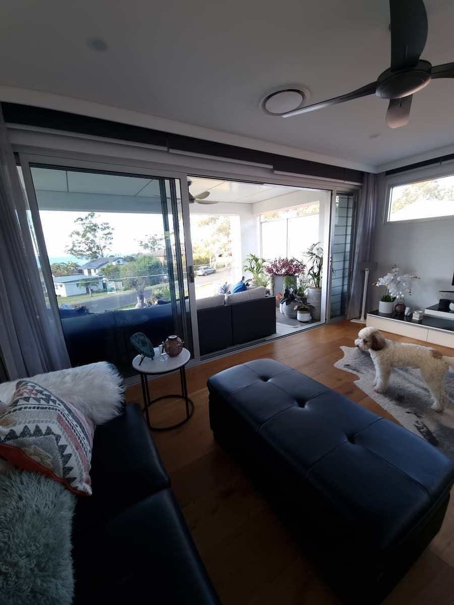 A Living Room With A Couch, Ottoman, Table And A Dog — South Coast Glass In South Nowra, NSW