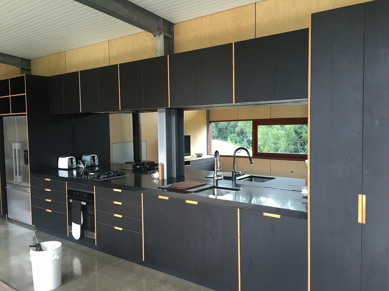 A Kitchen With Black Cabinets And Stainless Steel Counter Tops — South Coast Glass In South Nowra, NSW
