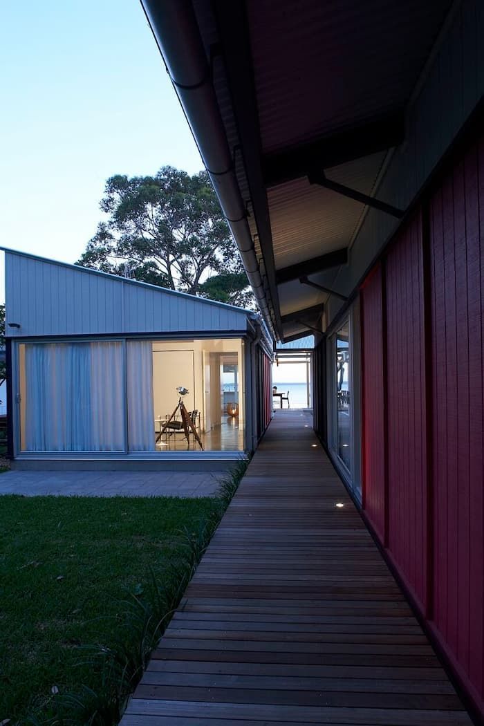 A Wooden Walkway Between Two Buildings With Red Walls — South Coast Glass In South Nowra, NSW