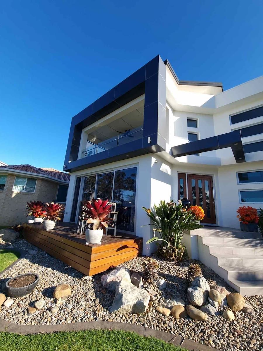 A Large White House With A Wooden Deck In Front Of It — South Coast Glass In South Nowra, NSW