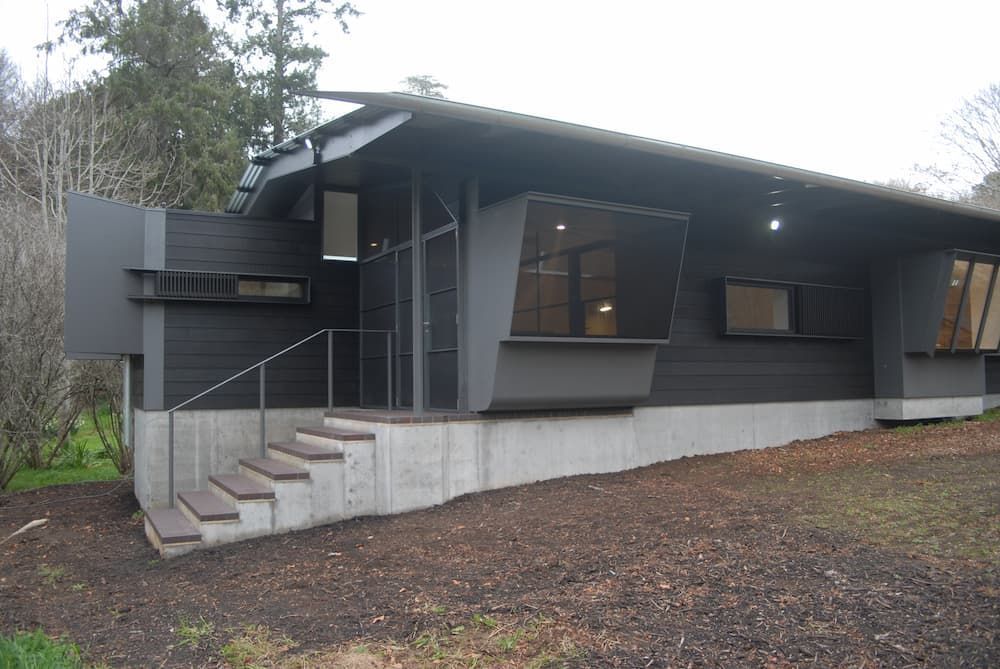 A Black House With Stairs Leading Up To The Front Door — South Coast Glass In South Nowra, NSW