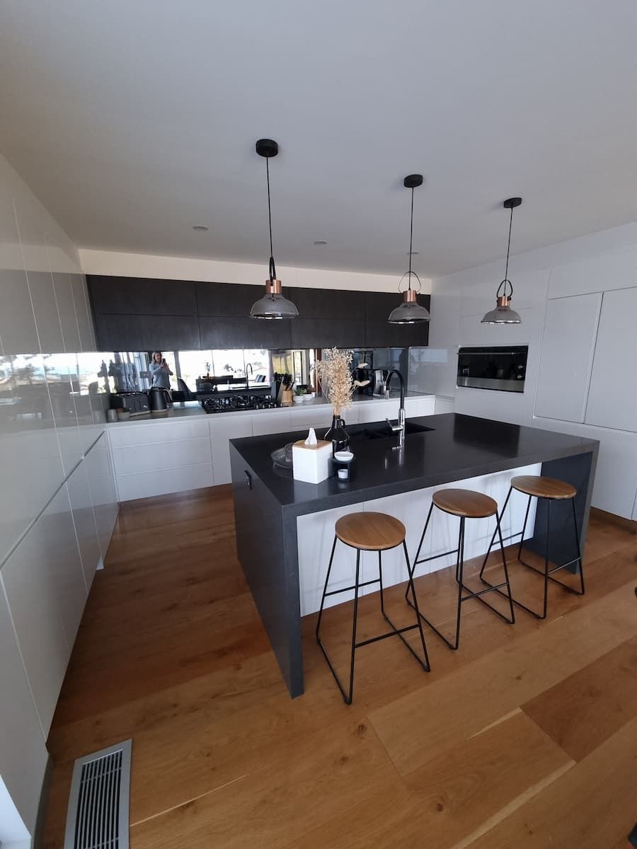A Kitchen With A Large Island And Stools In It — South Coast Glass In South Nowra, NSW