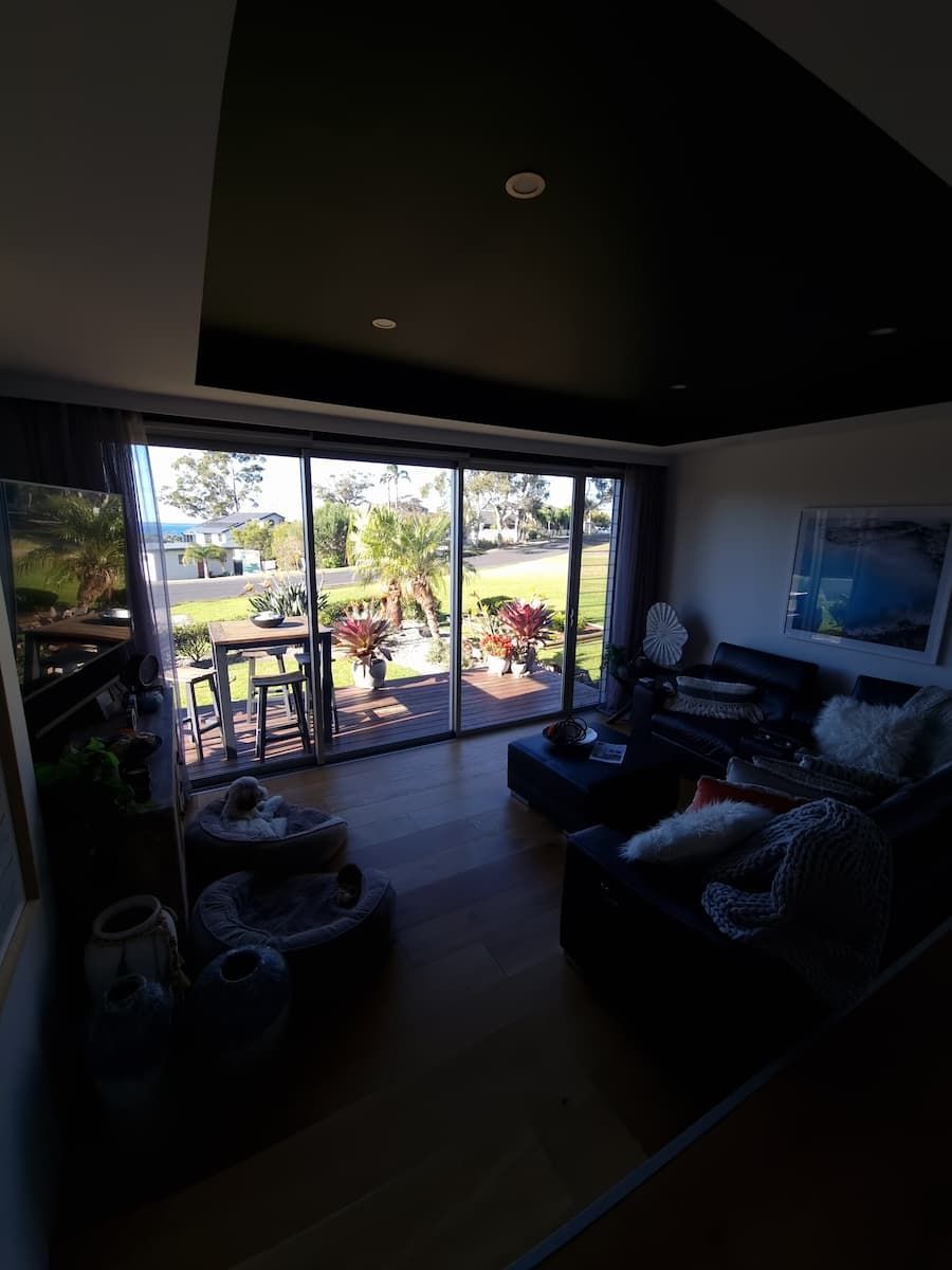 A Living Room With A Couch And A Sliding Glass Door Leading To A Patio — South Coast Glass In South Nowra, NSW