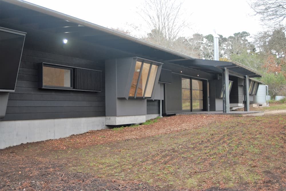 A Large Black House With A Lot Of Windows Is Sitting In The Middle Of A Field — South Coast Glass In South Nowra, NSW