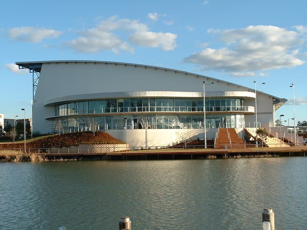 A Large White Building Sits Next To A Body Of Water — South Coast Glass In South Nowra, NSW
