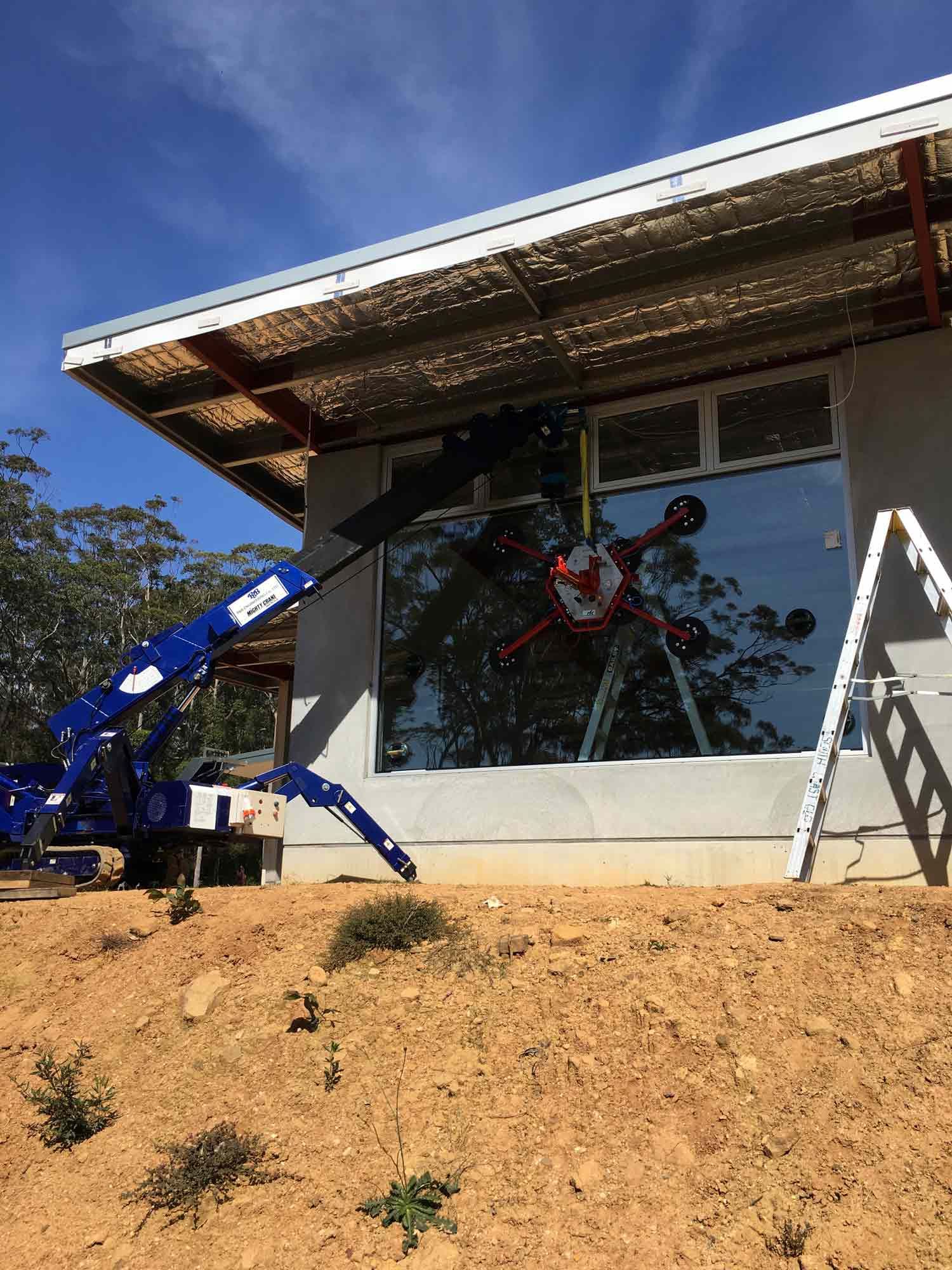 A Blue Crane Using for Glass Installation in House — South Coast Glass In South Nowra, NSW