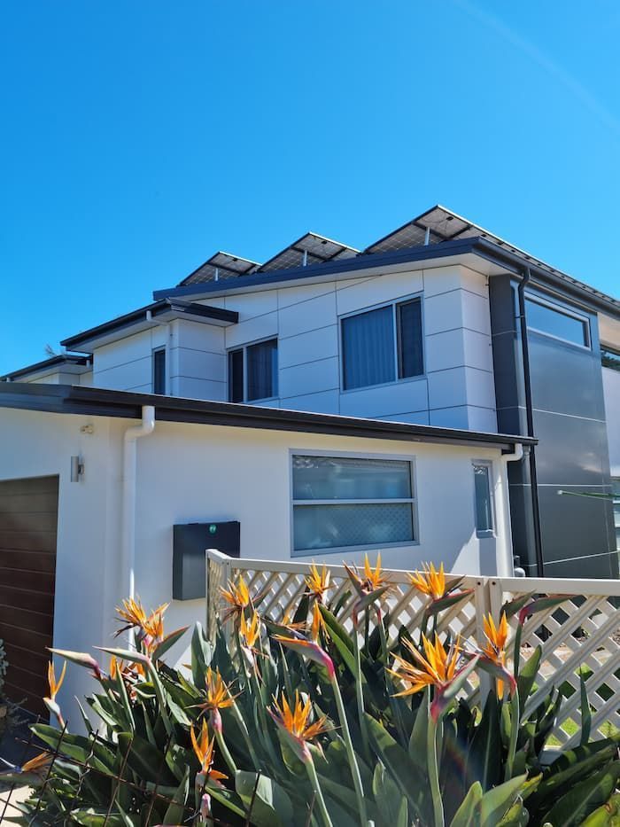 A White House With A Fence And Flowers In Front Of It — South Coast Glass In South Nowra, NSW
