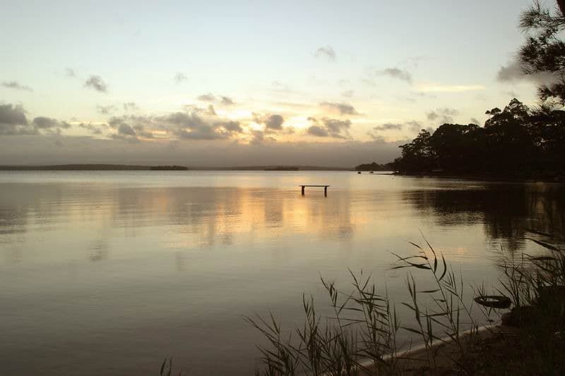 A Large Body Of Water With A Sunset In The Background — South Coast Glass In South Nowra, NSW