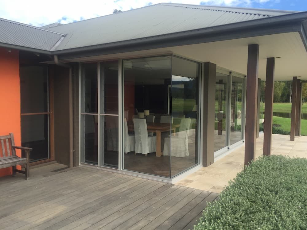 A Large House With A Lot Of Windows And A Wooden Deck — South Coast Glass In South Nowra, NSW