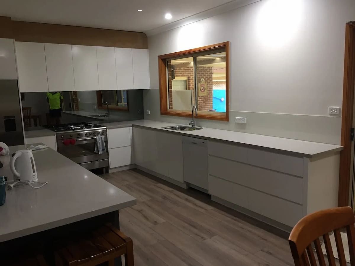A Kitchen With White Cabinets And A Large Window — South Coast Glass In South Nowra, NSW