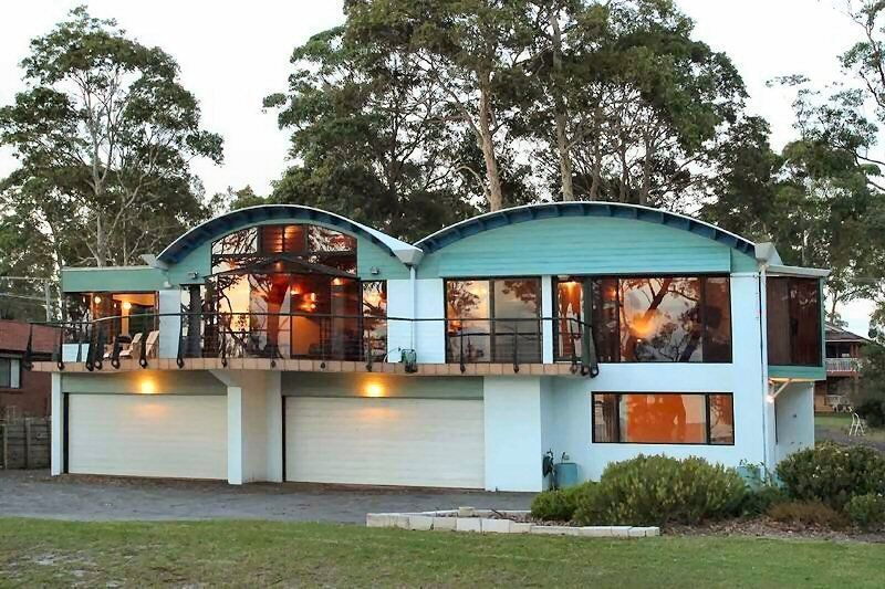 A House With A Balcony And Two Garages Is Surrounded By Trees — South Coast Glass In South Nowra, NSW