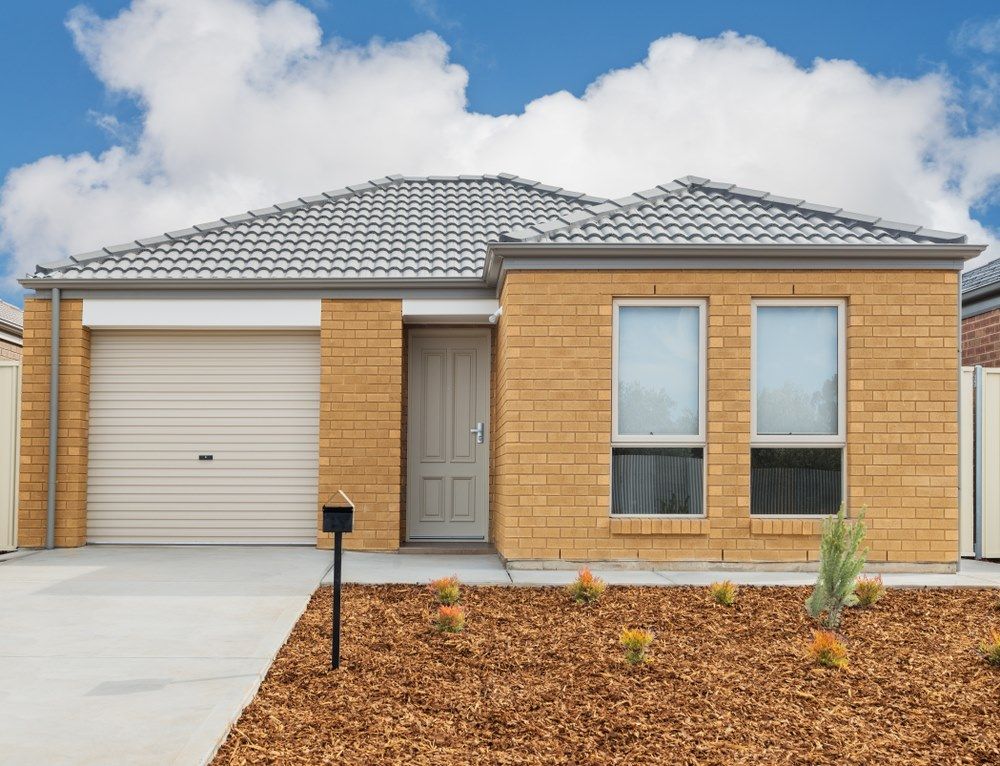 A Small Brick House With a White Garage Door — All Clean Pressure Cleaning in Lake Macquarie, NSW