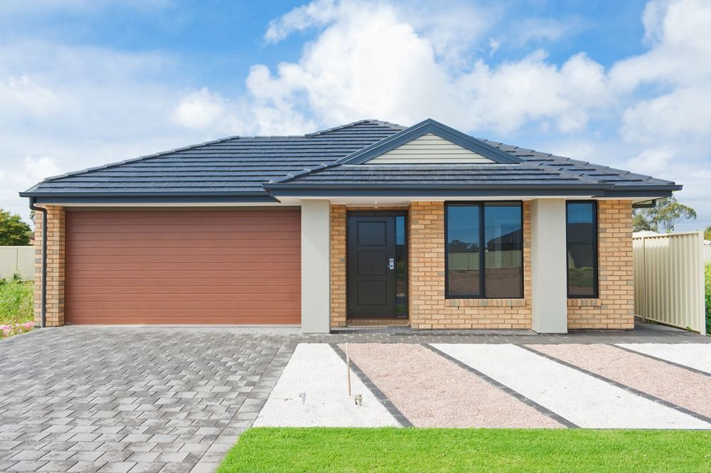 A Brick House With a Garage and a Driveway — All Clean Pressure Cleaning in Valentine, NSW