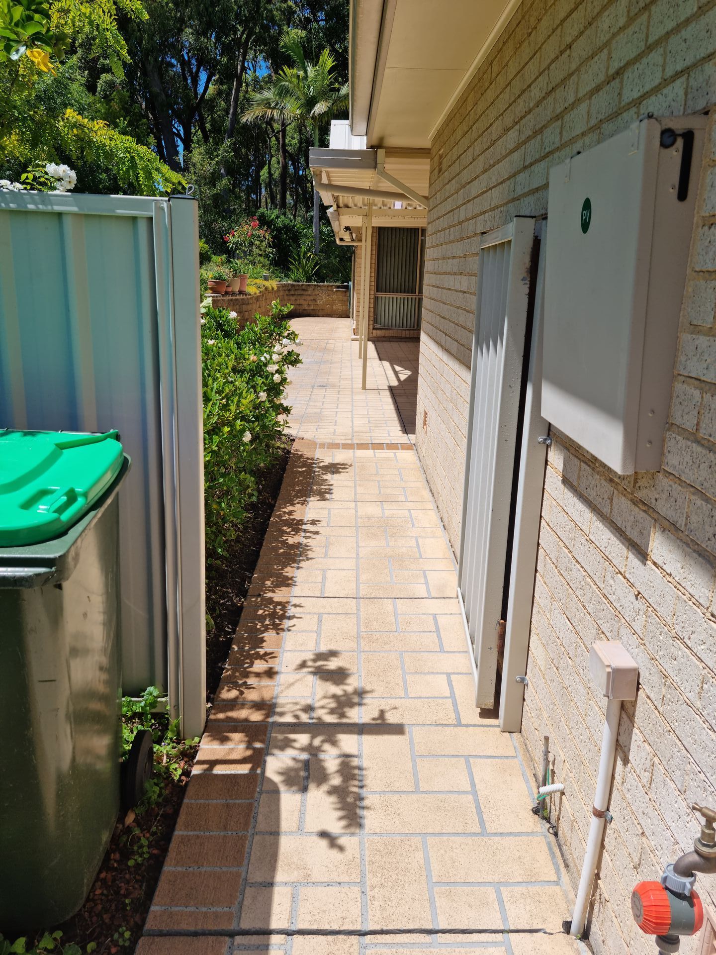 A Walkway Leading to a House With a Green Trash Can on the Side — All Clean Pressure Cleaning in Valentine, NSW