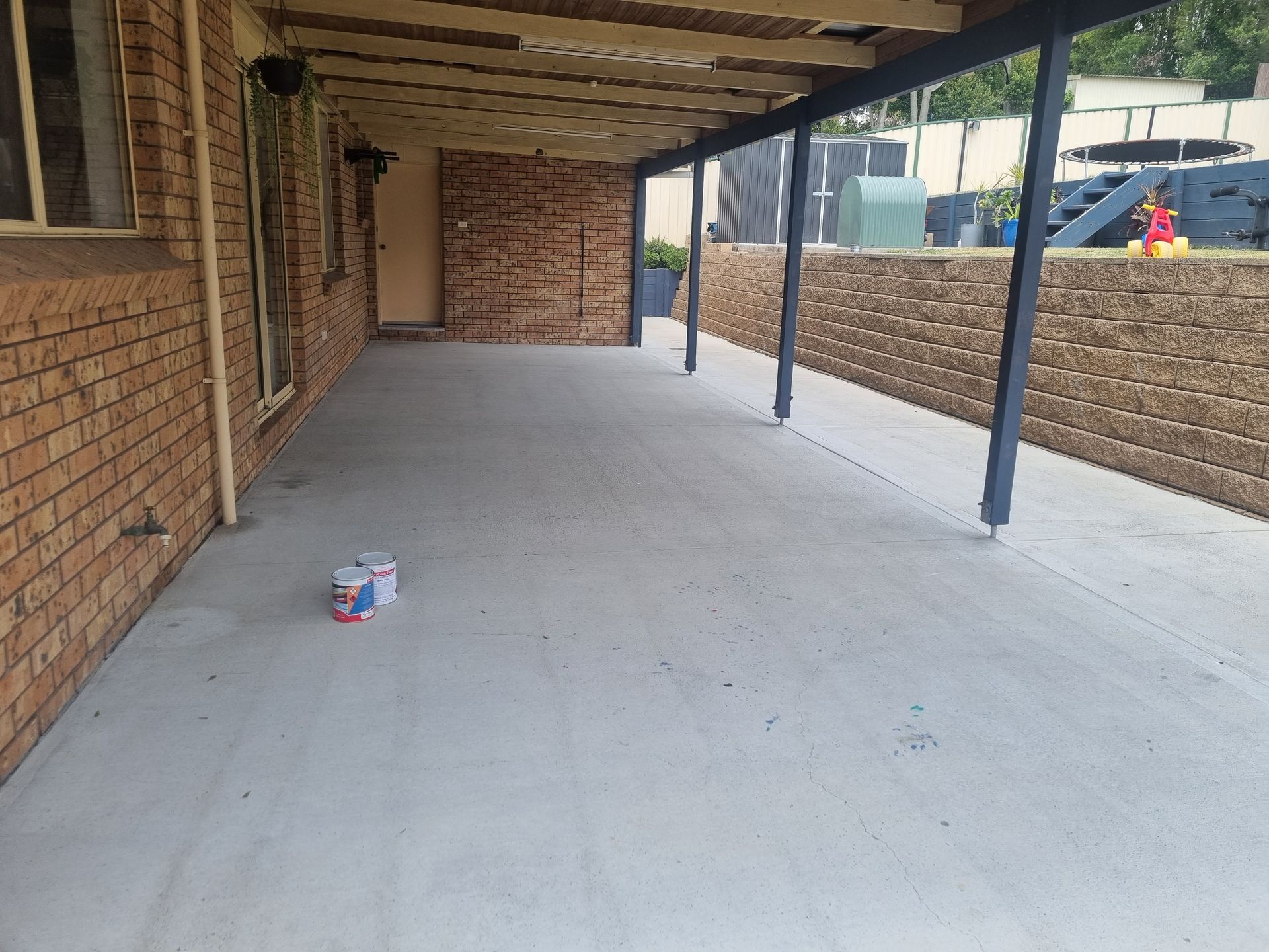A Concrete Patio With a Brick Wall and a Brick Wall Behind It — All Clean Pressure Cleaning in Valentine, NSW