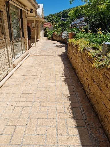 A Brick Walkway Leading to a House on a Sunny Day — All Clean Pressure Cleaning in Valentine, NSW