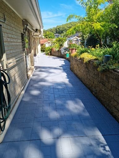A Brick Walkway Leading to a House on a Sunny Day — All Clean Pressure Cleaning in Valentine, NSW