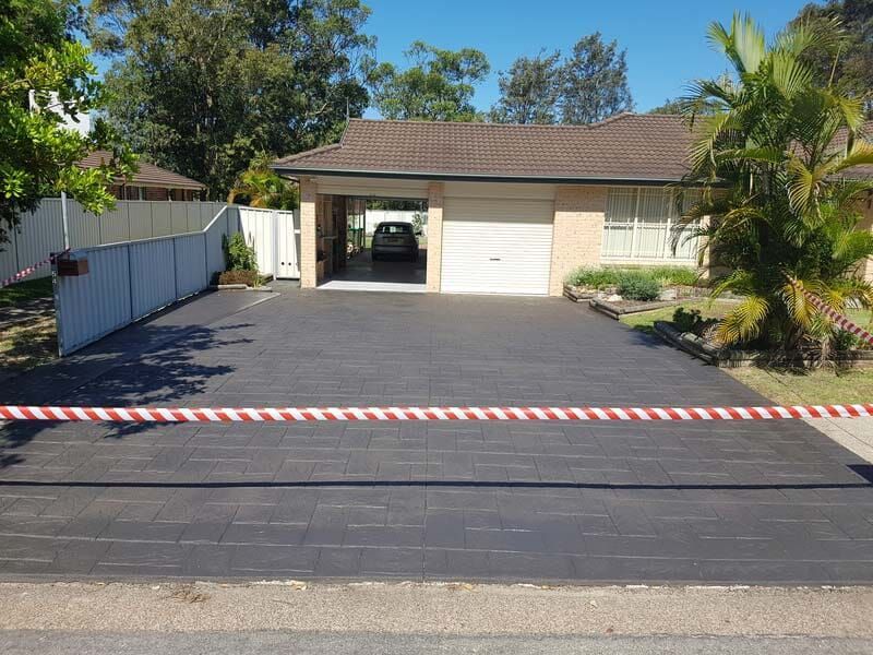 A Car is Parked in a Driveway in Front of a House — All Clean Pressure Cleaning in Valentine, NSW