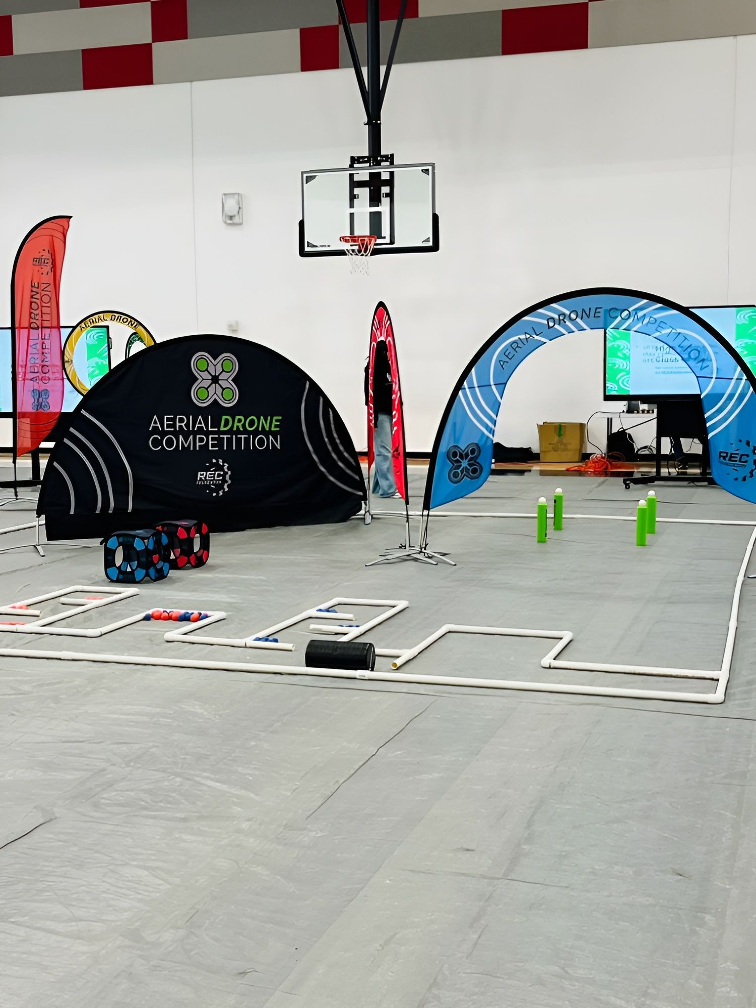 Aerial drone competition in a STEM event, showcasing teams maneuvering and programming drones through obstacle courses.