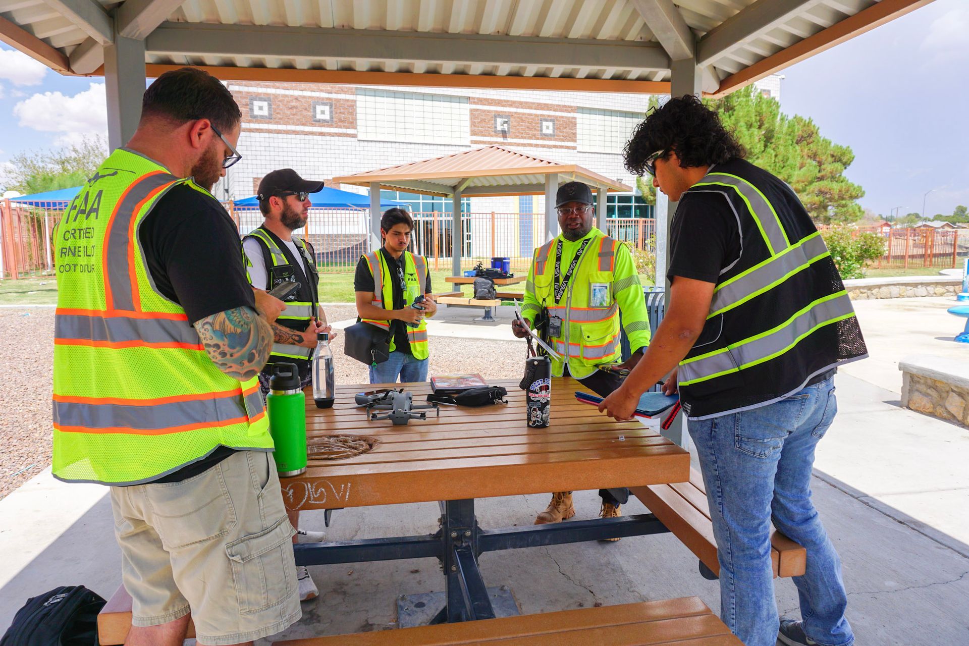 From Above Droneworks crew in safety vests reviewing flight plans.