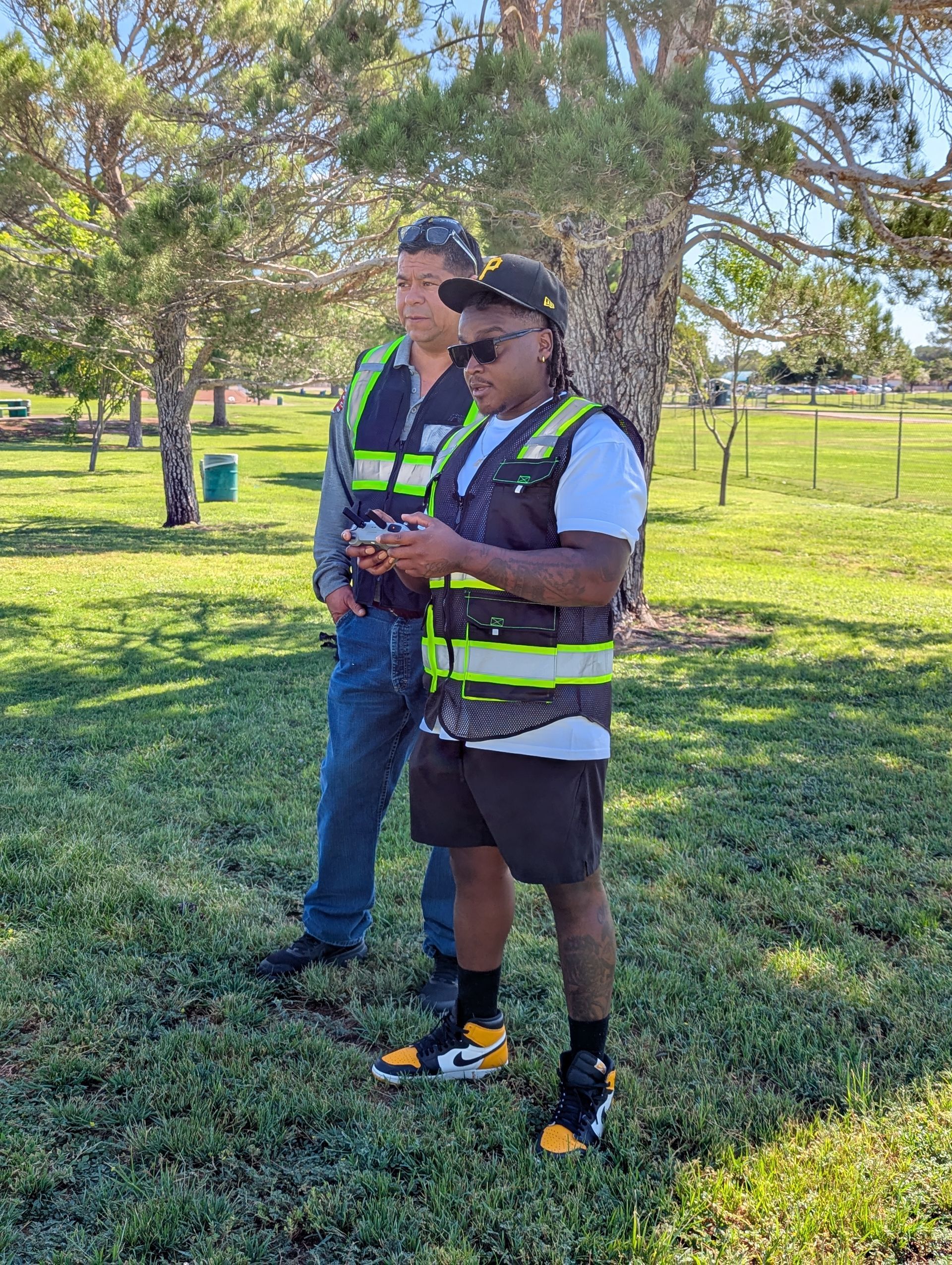 Trainee pilot flying a drone during FAA Part 107 practice session in El Paso, guided by an instructor.