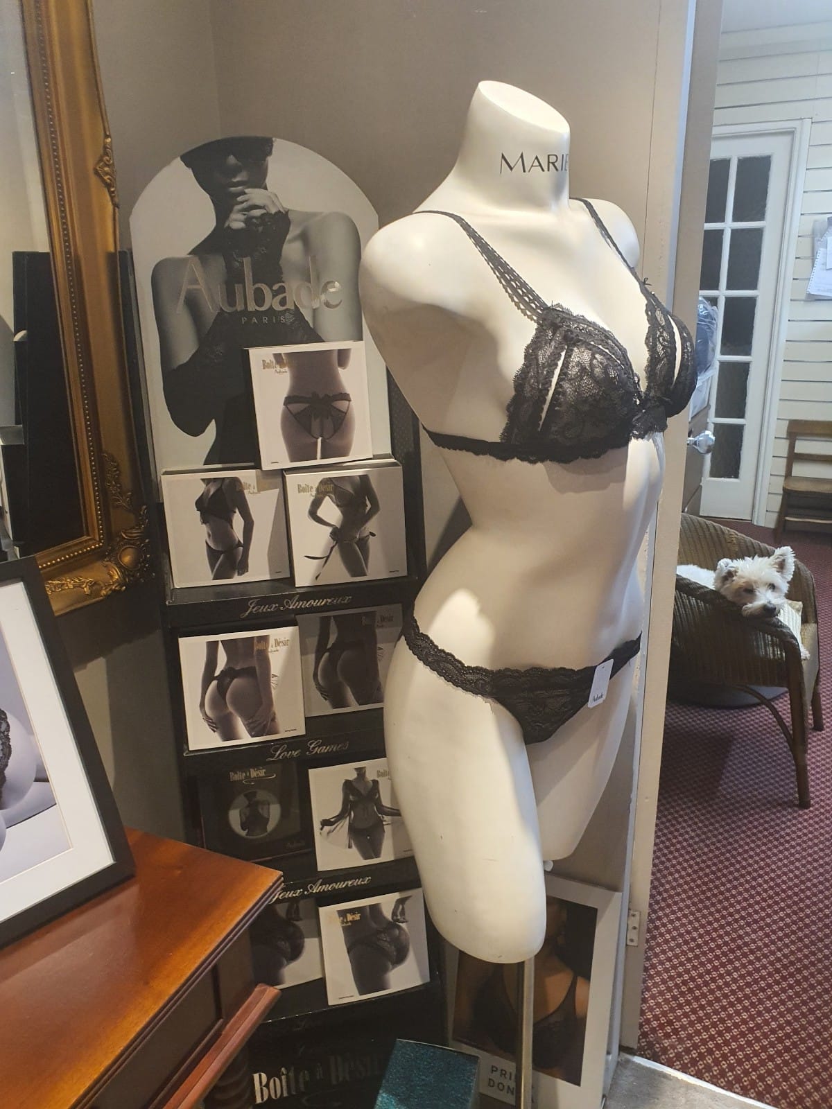 A mannequin is wearing a black bra and thong